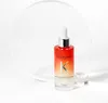 A Kérastase hair serum bottle is displayed on a white background with a clear circular acrylic piece behind it and a clear cube to the right. Podgląd zdjęcia produktu