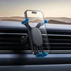 A smartphone car mount attached to a car's air vent, with a phone in the mount. The background shows a blurred landscape. Produktbild-Vorschau