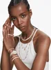 A woman wearing multiple pieces of jewelry, including necklaces, bracelets, and rings. Anteprima dell’immagine prodotto