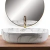 A marble-patterned sink with a gold faucet is shown against a mirrored background. Anteprima dell’immagine prodotto