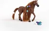 A brown toy horse with long brown hair styled with purple and teal clips, standing on a white background. Accessories are scattered in the foreground. Voir les images du produit