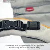 Close-up of a buckle and strap on a baby carrier, with text overlay. Produktbild-Vorschau