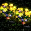 Solar powered flower lights in a garden at night. Náhled obrázku produktu