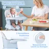 A mother feeding her baby in a high chair at a table. Podgląd zdjęcia produktu