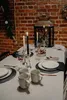 A table set for a meal with plates, mugs, candles, and a lantern. Náhľad obrázku produktu