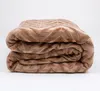 A folded brown blanket with a chevron pattern is shown against a white background. Podgląd zdjęcia produktu