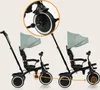 Two identical tricycles are shown side-by-side, with one having a magnified view of its front wheel and a diagram highlighting a feature. Produktbild-Vorschau