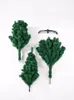 Three sections of a green artificial Christmas tree are laid out on a white background, along with a black metal tree stand. Podgląd zdjęcia produktu