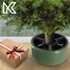 A Christmas tree stand with a gift box next to it. Podgląd zdjęcia produktu
