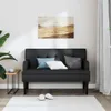 A black bench with cushions is placed against a white wall, with a landscape painting above it. A small side table with a cup and a plant are to the left, and curtains are to the right. Slippers are on the floor in front of the bench. Náhled obrázku produktu