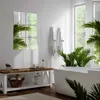 A bright and airy bathroom with a freestanding bathtub, plants, and a wooden bench. Produktbild-Vorschau