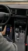 A person is holding a smartphone that is plugged into a car's charging port. A portable power bank is also plugged into the car's charging port. Náhled obrázku produktu