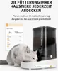 A cat eating from an automatic pet feeder, with a smartphone app interface shown in the background. Produktbild-Vorschau