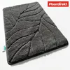 A dark gray bath mat with a leaf pattern, shown from a slightly elevated angle on a white background. Produktbild-Vorschau