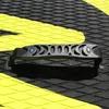 A close-up view of a black handle with a yellow stripe on a black and yellow textured surface. Náhled obrázku produktu