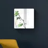 Quadratischer Wandspiegel mit abgerundeten Ecken, der eine grüne Pflanze und ein Fenster reflektiert, montiert an einer dunkelblauen Wand über einem gelben Kissen Anteprima dell’immagine prodotto