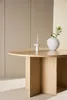 A light wood dining table with a candle holder and a vase with greenery on it, set against a neutral background. Voir les images du produit