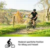A person riding a mountain bike on a dirt path with a town in the background during autumn. Produktbild-Vorschau
