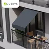 A balcony with a gray awning extended over a small table and chair. Náhľad obrázku produktu