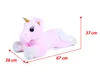 A pink plush unicorn toy lying down, with dimensions indicated by red lines and text. Produktbild-Vorschau