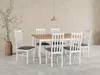 A dining set with a wooden table and six white chairs with dark gray cushions, set against a textured beige wall and a gray floor. Produktbild-Vorschau