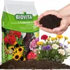 A bag of BIOVITA universal soil for flowers is shown, with hands holding some soil, and a pot of flowers in the foreground. Podgląd zdjęcia produktu