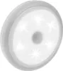 A white, circular LED night light with a motion sensor in the center, viewed from a slightly elevated angle. Voir les images du produit