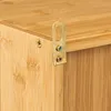 A close-up view of a wooden cabinet's corner, showing a metal hanging bracket and screws. Podgląd zdjęcia produktu