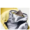 Close-up view of the inside of a yellow backpack, showing a wallet and keys in a zippered pocket. Produktbild-Vorschau