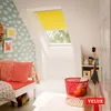 A child's bedroom with a skylight window covered by a yellow roller blind. Produktbild-Vorschau