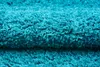 A close-up view of a fluffy, turquoise shaggy rug. Produktbild-Vorschau
