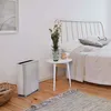 A bedroom scene with an air purifier next to a bed. Podgląd zdjęcia produktu