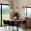 A dining room with a table, chairs, and pendant lights, with a large window showing a landscape view. Anteprima dell’immagine prodotto