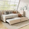 A beige upholstered daybed with a trundle bed pulled out, in a brightly lit room with large windows. Náhled obrázku produktu