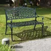 A dark green metal garden bench sits on a lawn with a gravel path in the foreground. People are visible in the background. Produktbild-Vorschau