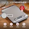 A digital kitchen scale is shown on a wooden surface, with ingredients like flour and sugar in the background. Produktbild-Vorschau