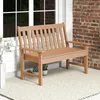A brown plastic garden bench is placed on a rug in front of a brick wall and a white-paneled wall with a window. Produktbild-Vorschau