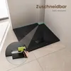 A black shower tray with a textured surface is shown in a bathroom corner, with a close-up inset demonstrating how it can be cut to size. Anteprima dell’immagine prodotto