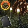 Close-up of LED lights on a Christmas tree with a pine cone in the background. Produktbild-Vorschau