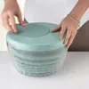 Hands operating a salad spinner. Produktbild-Vorschau