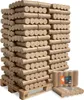 A large stack of compressed wood briquettes on a wooden pallet, with a few briquettes in the foreground. Produktbild-Vorschau