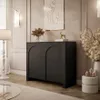 A modern living room with a black sideboard, a floor lamp, and decorative items. Produktbild-Vorschau