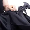 A person's hands are zipping up a black scooter cover. Produktbild-Vorschau
