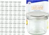 A collection of small glass jars with silver lids, alongside a booklet with text. Náhled obrázku produktu