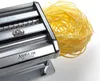 A close-up shot of a silver pasta maker with freshly made yellow pasta. Anteprima dell’immagine prodotto