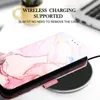 A phone case with a marble pattern is placed on a wireless charger. Produktbild-Vorschau
