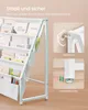 A white children's bookshelf with books and pockets on the side. Two inset images show safety features: a wall anchor and adjustable feet. Produktbild-Vorschau