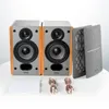 Two bookshelf speakers and accessories are arranged on a white surface. Produktbild-Vorschau