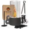 A tabletop fireplace with a flame is displayed with its accessories and packaging. Produktbild-Vorschau