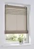A Roman blind is shown hanging in a window, with a garden visible outside. Produktbild-Vorschau